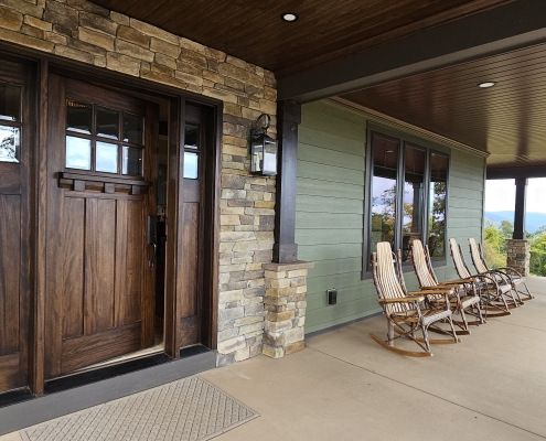 custom home front porch with stone and green siding