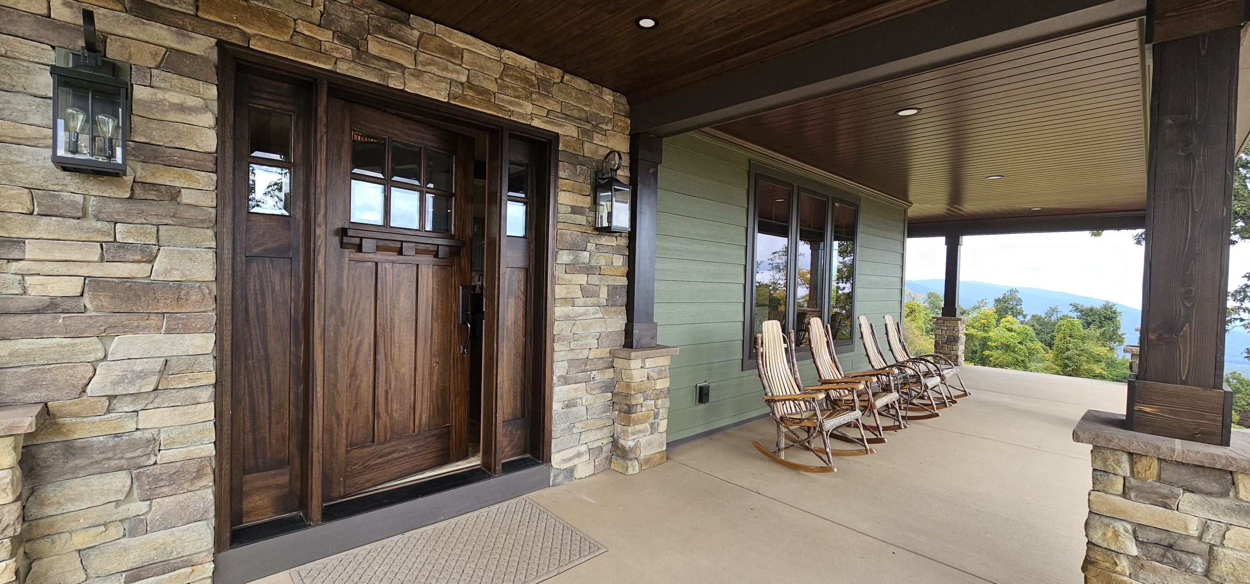 custom home front porch with stone and green siding