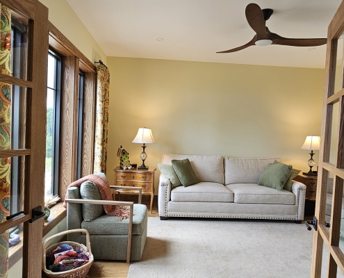 custom home living room looking at tan sofa with windows to the side