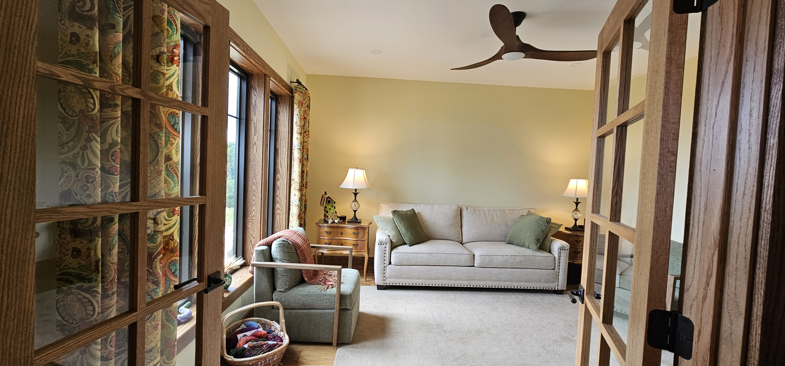 custom home living room looking at tan sofa with windows to the side