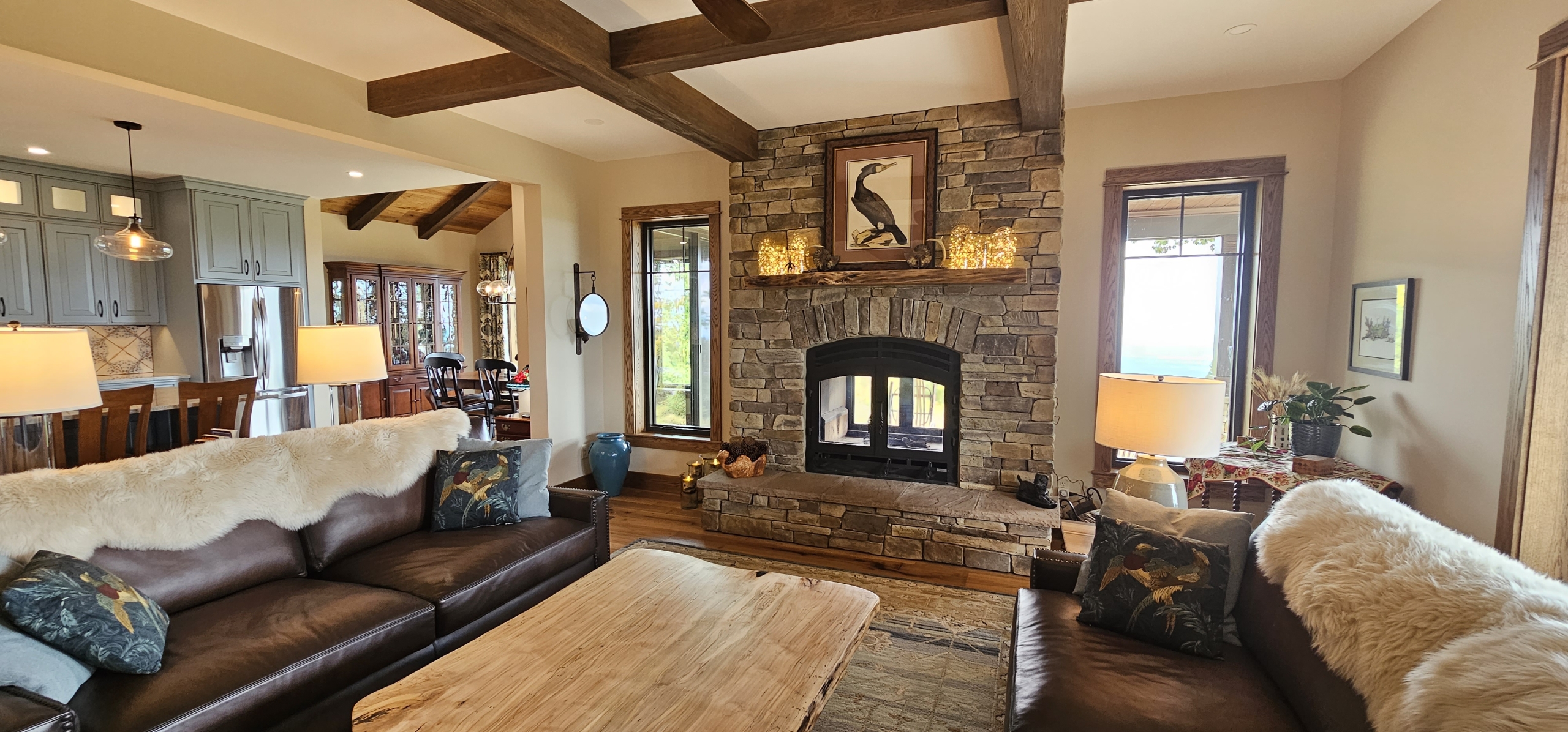 view of stone chimney in living room and fireplace that opens to porch and living room