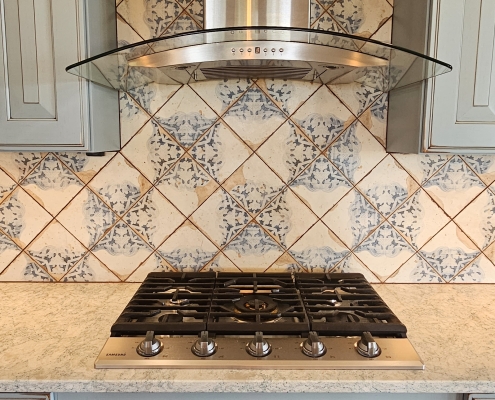 built in range with tile backsplash and range hood