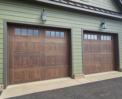 wood garage doors in green siding