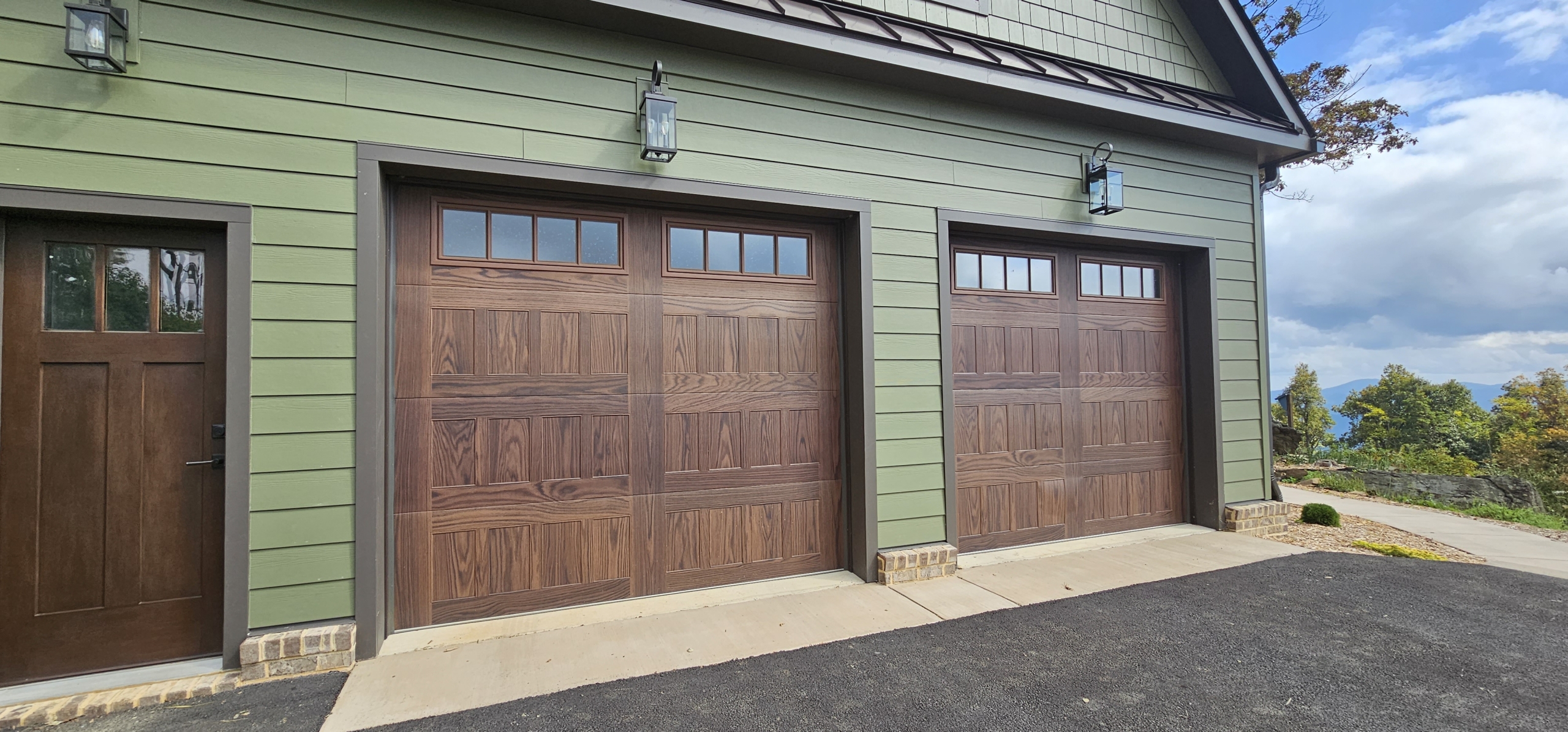 wood garage doors in green siding